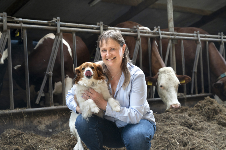 Gerda Kool met hond in koeienstal
